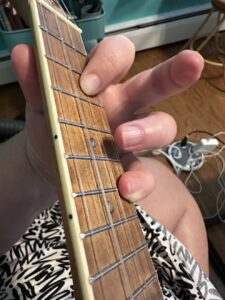 close up of a ukulele and a player's left hand